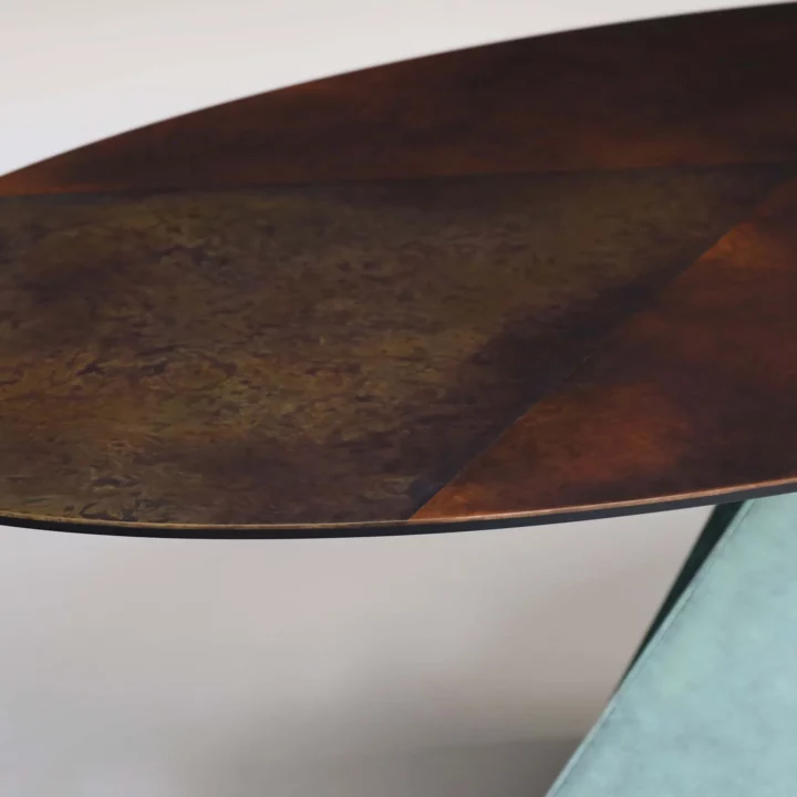 Detail on the Avebury oval dining table in steel finished in ‘Verdigris’ with a segmented mottled bronze and brass top