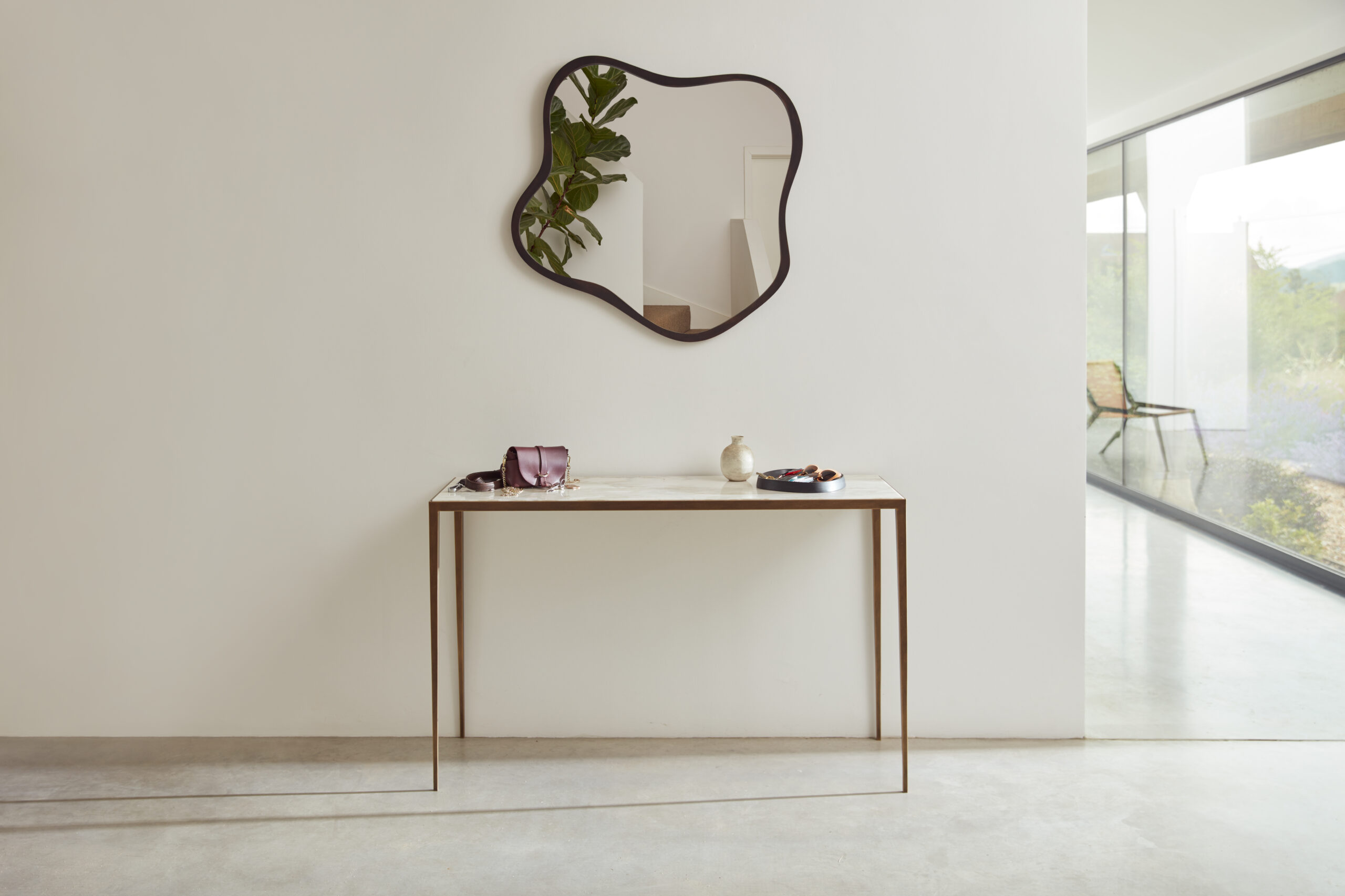 Flint console finished in ‘Florentine Gold’ with a Calacatta Oro marble top + Lily mirror finished in ‘Bronze’